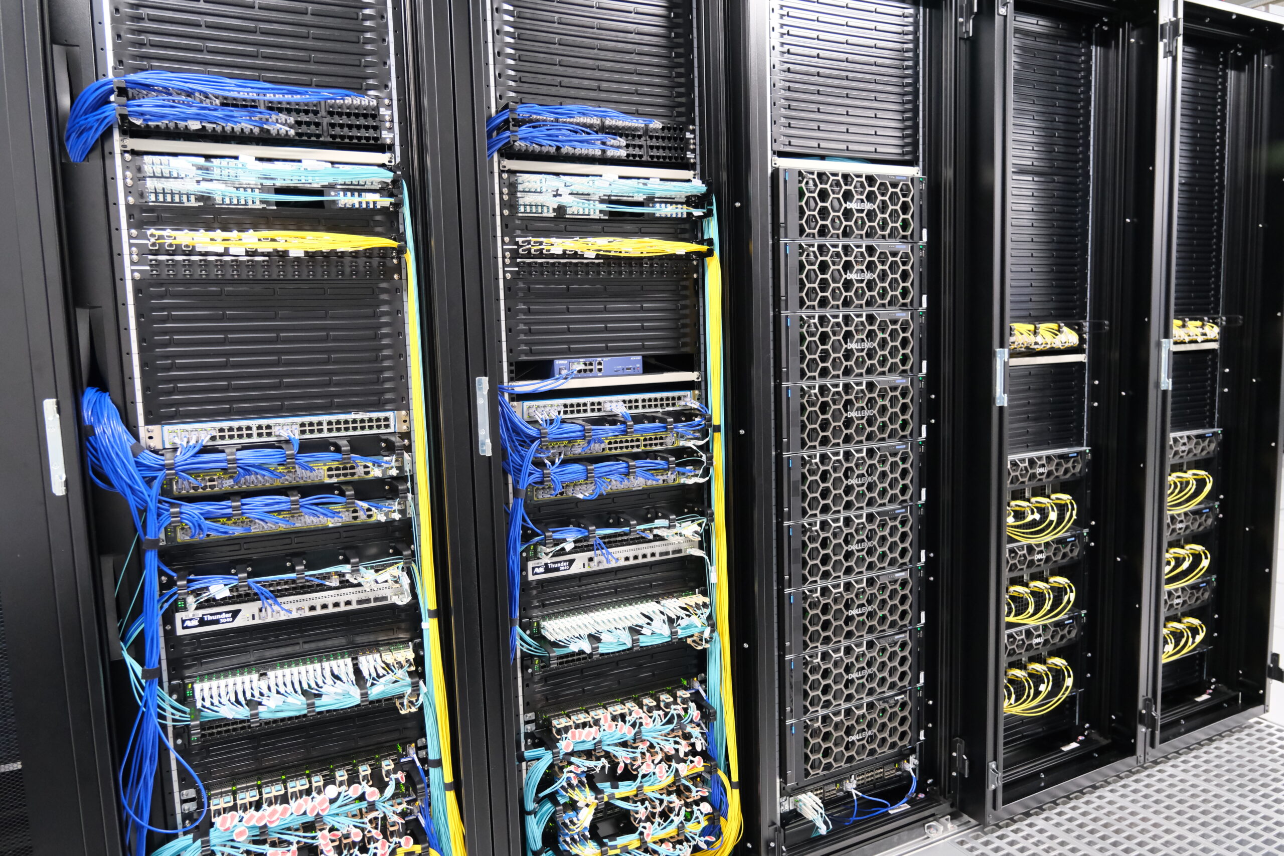 NVIDIA H100 機械学習基盤(右)とネットワーク設備(左)の写真